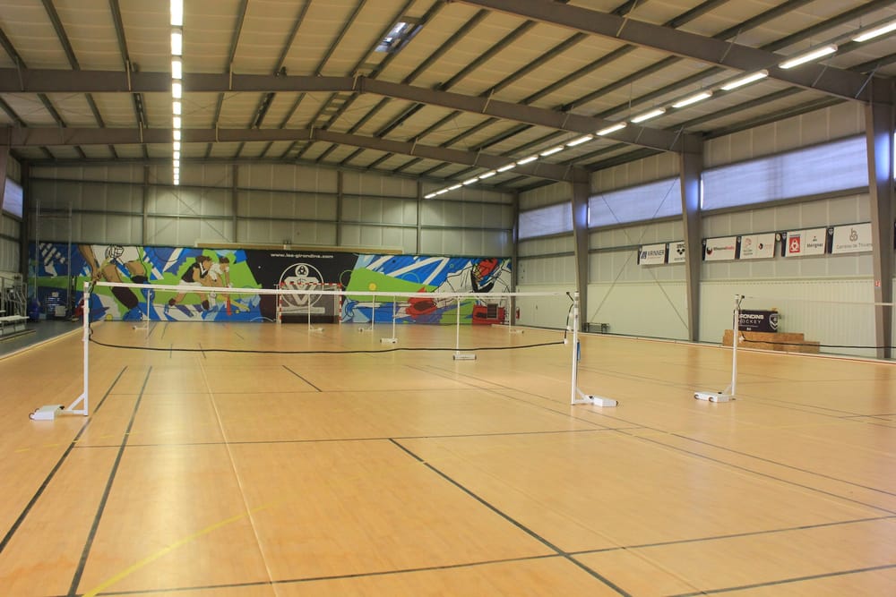 Filets de badminton montés dans le gymnase, parquet clair