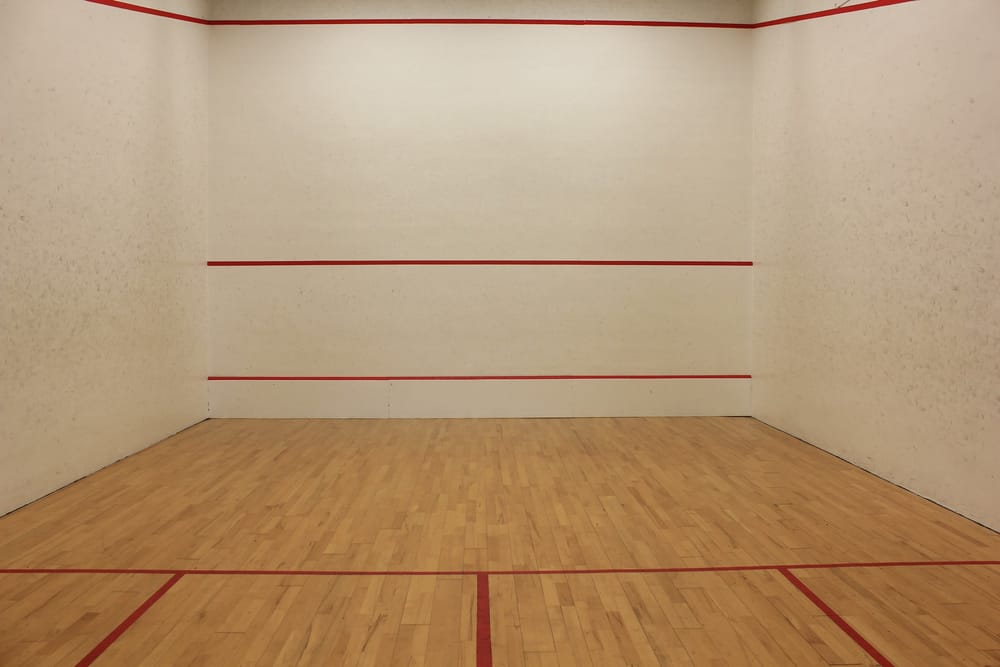 Court de squash, parquet et murs blancs
